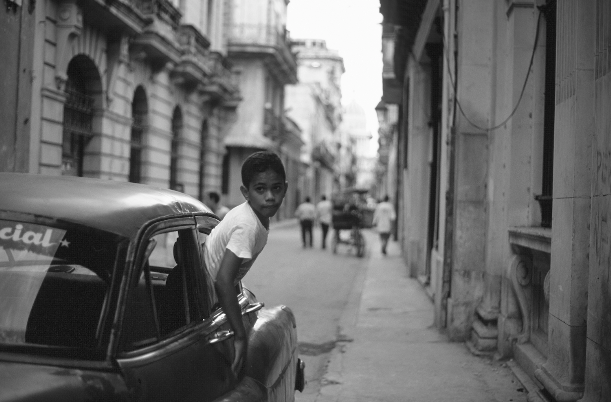 Enfant cubain par la vitre d’une voiture